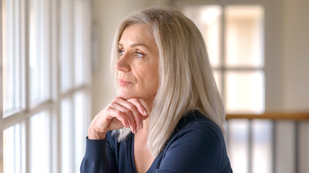 Csinos, gondolkodó nő komoly arckifejezéssel