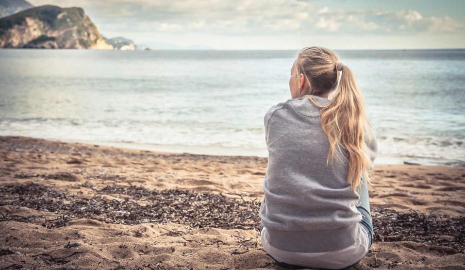 nő egyedül ül a tengerparton