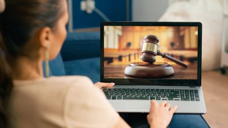 Nő az otthonából laptopon követi a bírósági tárgyalást