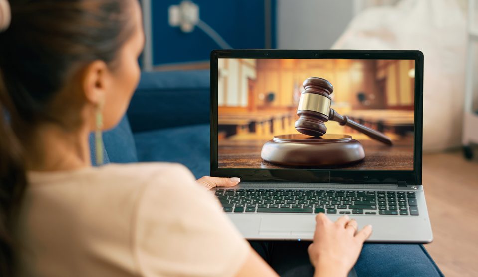 Nő az otthonából laptopon követi a bírósági tárgyalást