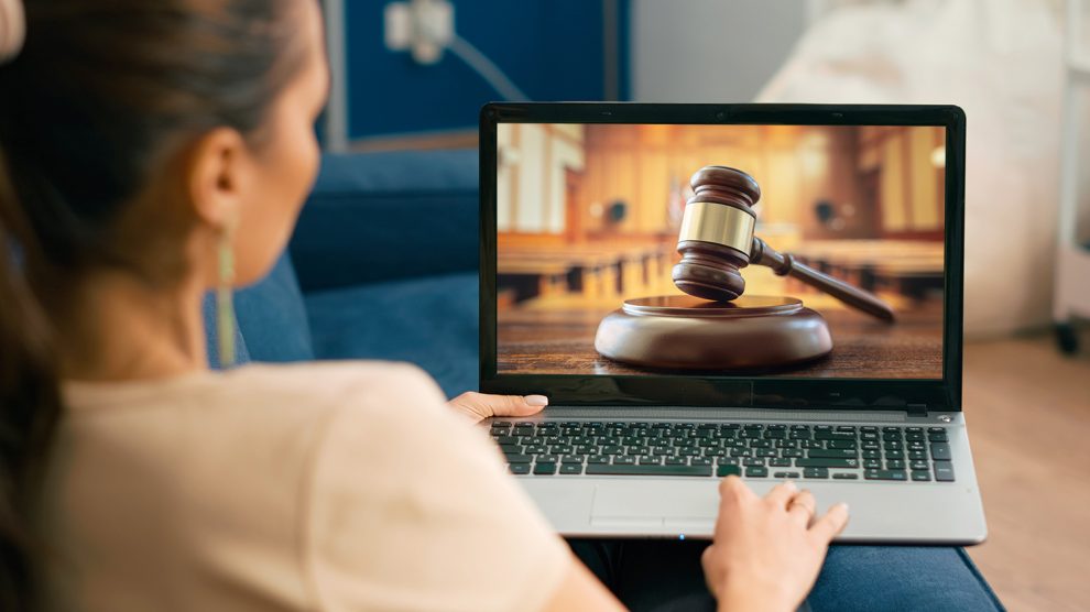 Nő az otthonából laptopon követi a bírósági tárgyalást