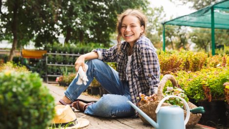kertészlány ül a kertben mosolyog
