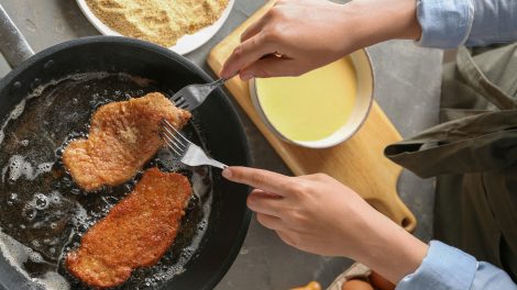 nő rántott húst süt bő olajban