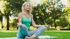 csinos idős hölgy jógázik a parkban