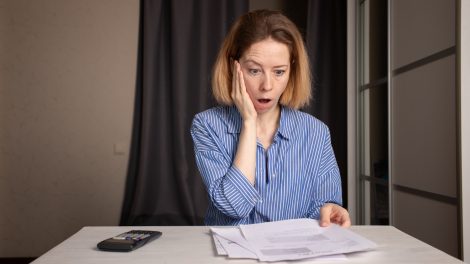 Villany számlát néz egy nő csodálkozva