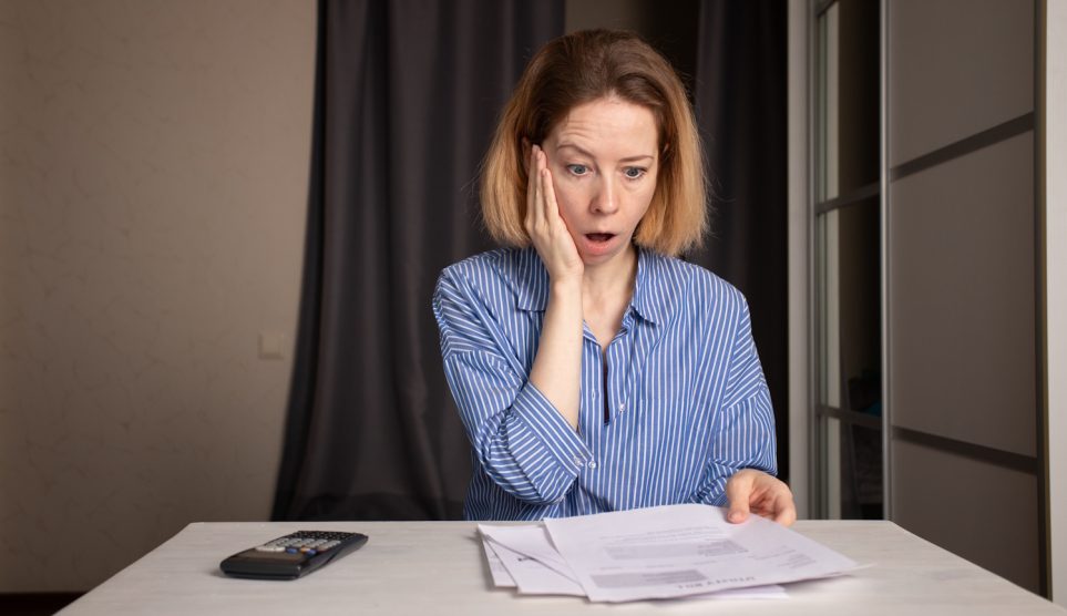 Villany számlát néz egy nő csodálkozva