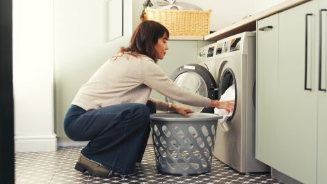 Szárítógépbe pakol be egy nő