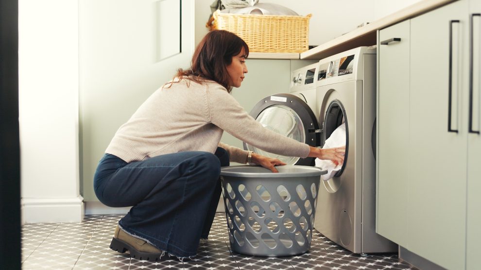 Szárítógépbe pakol be egy nő