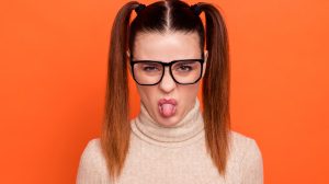 Egy lány grimaszol szemüveben