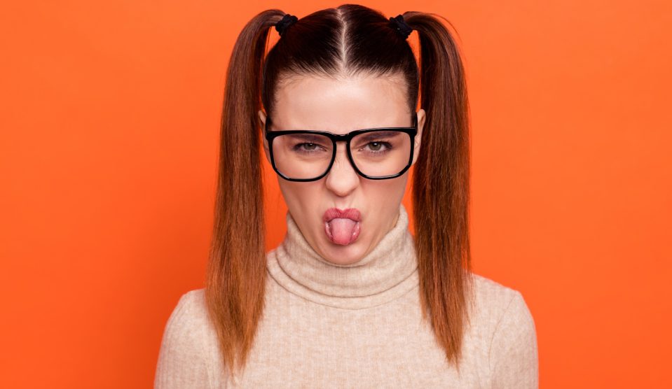 Egy lány grimaszol szemüveben