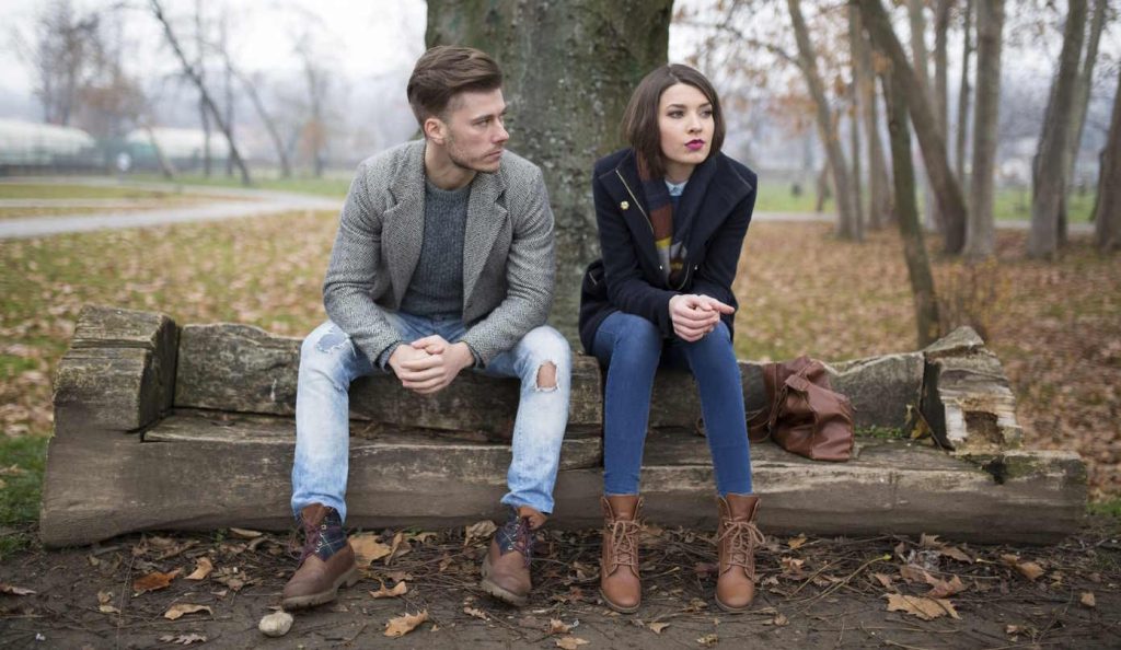 nem túl jókedvű pár ül egy farönkön