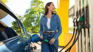 csinos nő örömmel tankol a benzinkúton