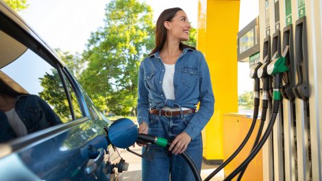 csinos nő örömmel tankol a benzinkúton