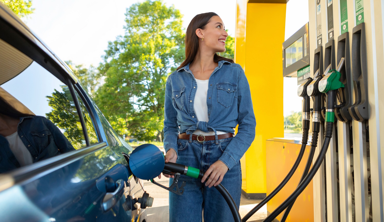 csinos nő örömmel tankol a benzinkúton