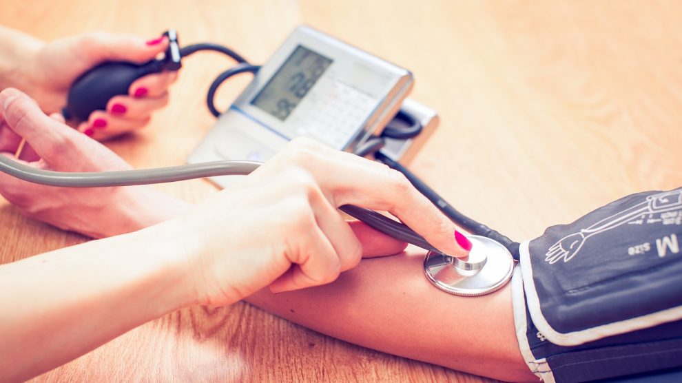 fiatal orvosnő a beteg vérnyomását méri