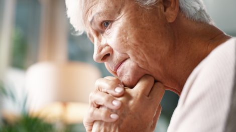 idős nyugdíjas néni aggódik, bánatosan néz ki az ablakon