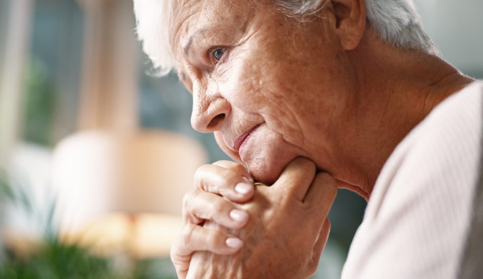 idős nyugdíjas néni aggódik, bánatosan néz ki az ablakon