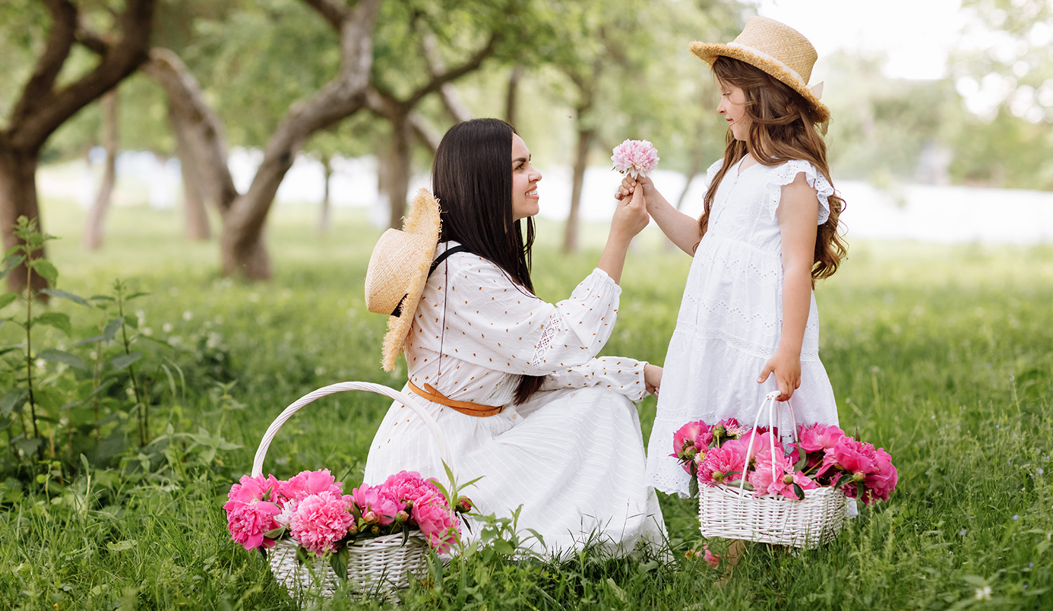 Kislány virágot ad ajándékba az édesanyjának a szabadban