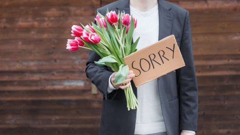férfi virággal kér bocsánatot