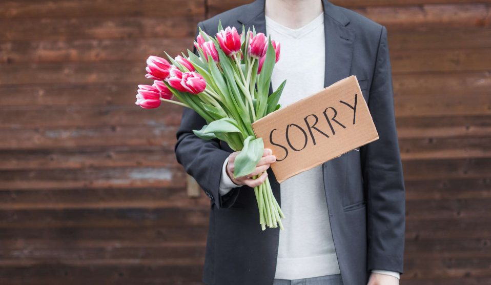férfi virággal kér bocsánatot