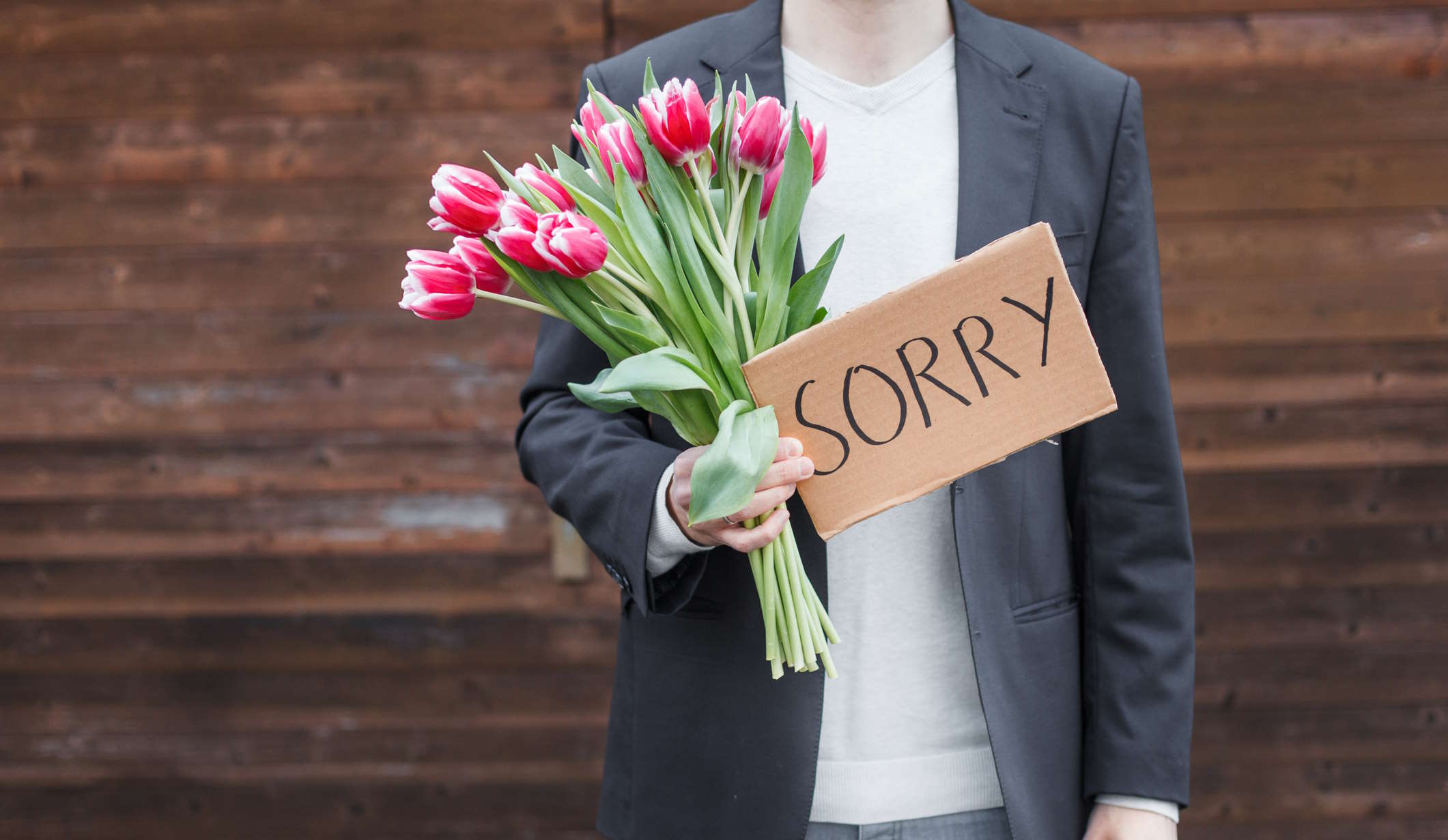 férfi virággal kér bocsánatot