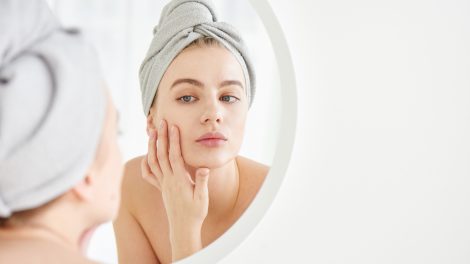 Egy lány krémet ken az arcára