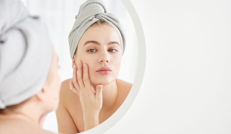 Egy lány krémet ken az arcára