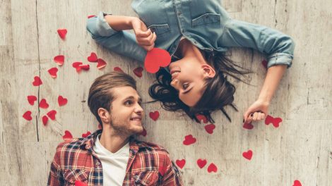 szerelmes pár fekszik a földön papírszívek között