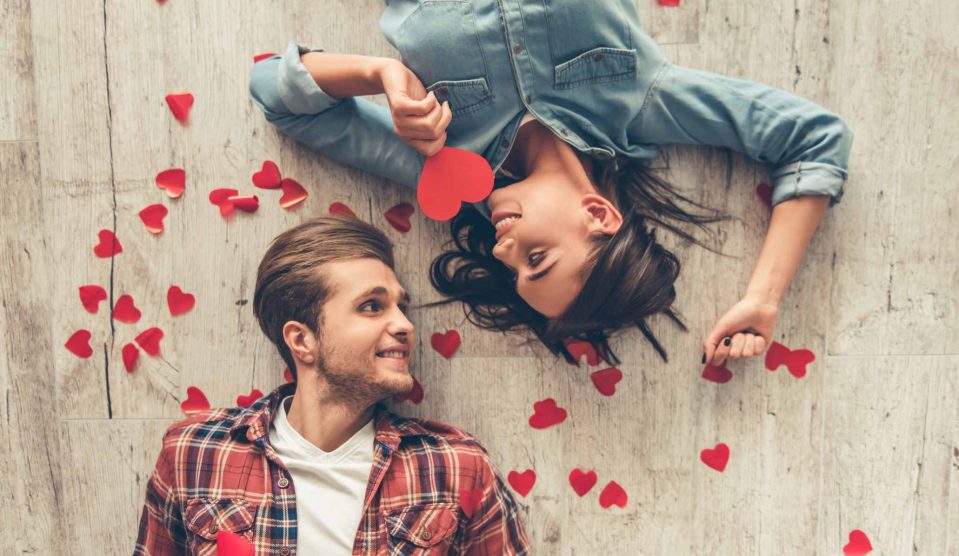 szerelmes pár fekszik a földön papírszívek között