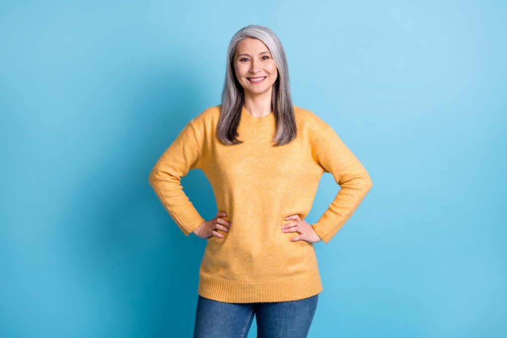 csípő alá érő pulóverben 60 éves nő