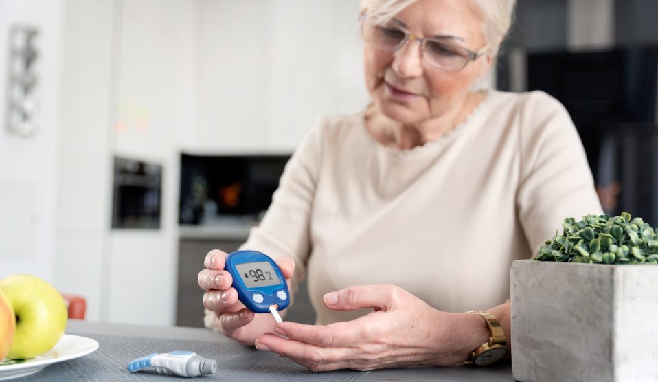 Egy idős hölgy méri a cukrát