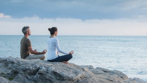 ár meditál napfelkeltekor a tengerparton