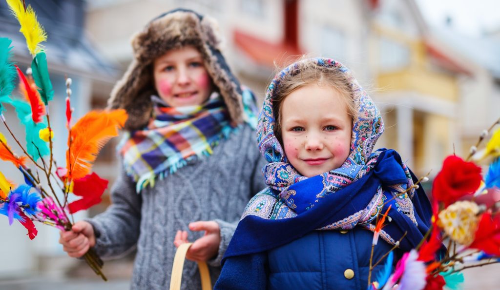 finn gyerekek feldíszített barkaágakkal húsvétkor elverik a felnőtteket