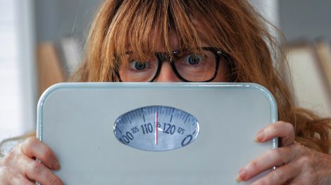 túlsúlyos nő mérleggel a kezében