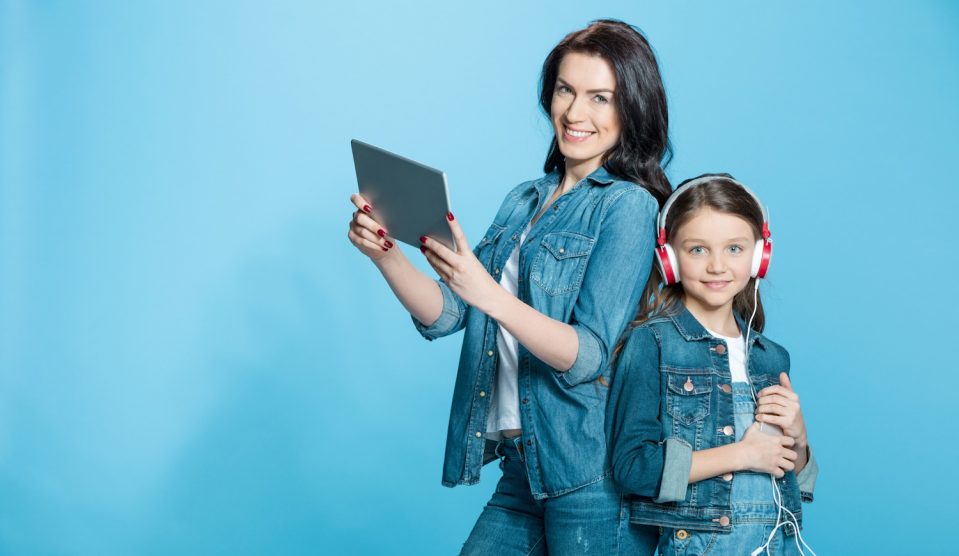 anyuka tablettel a kezében kislánya mellette fejhallgatóval