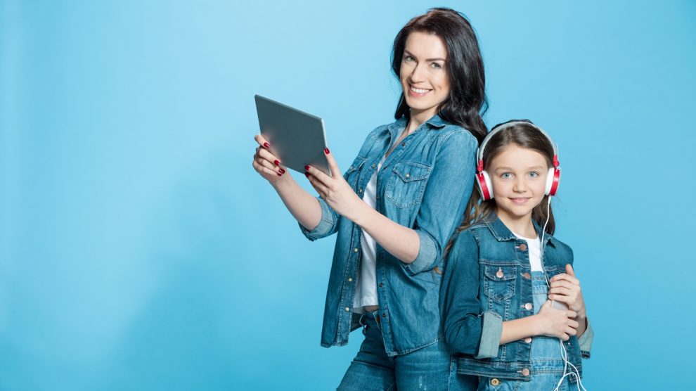 anyuka tablettel a kezében kislánya mellette fejhallgatóval