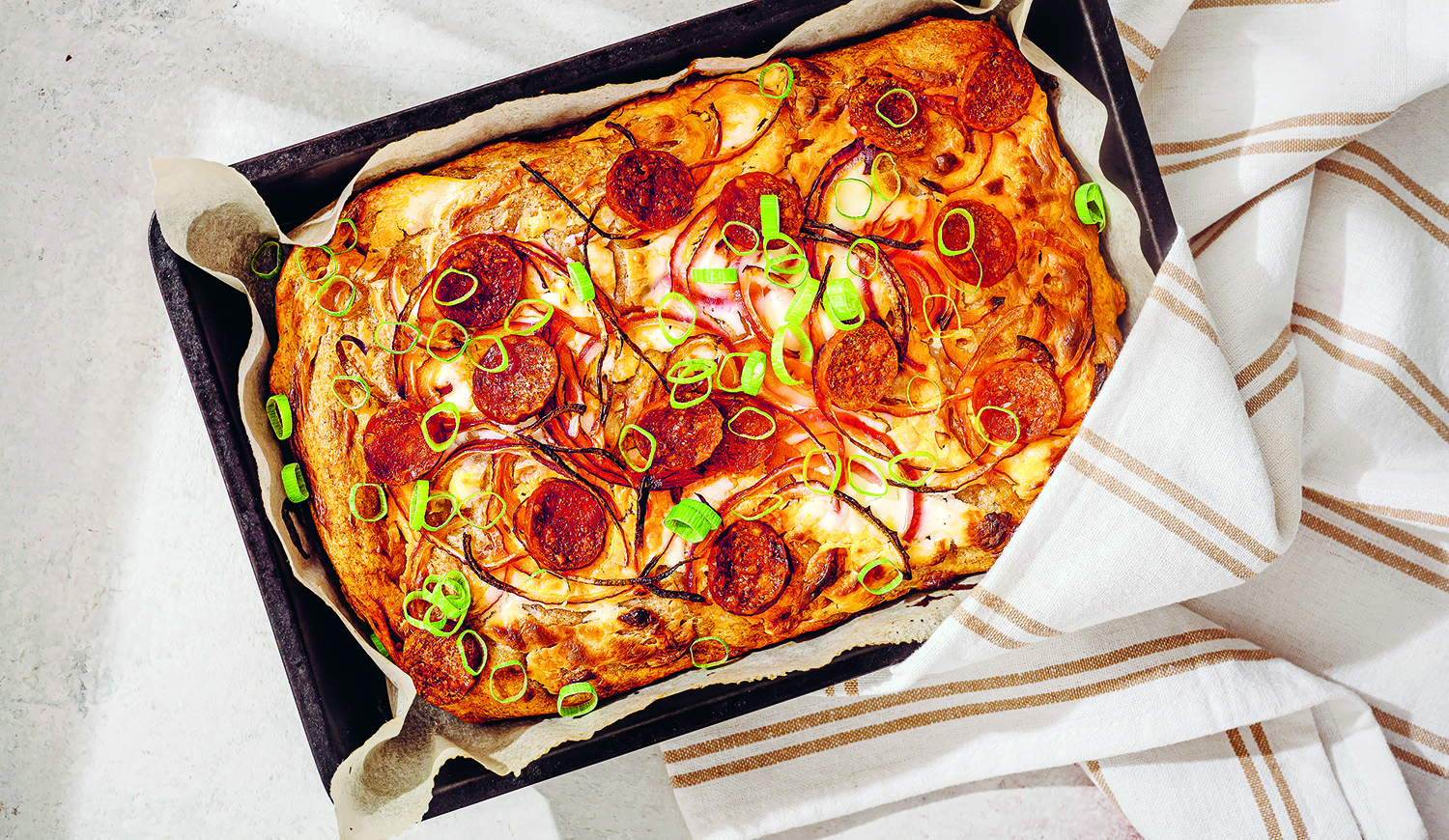 Kenyérlángos kolbásszal és lila hagymával