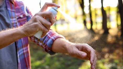 Egy férfi lefújja magát kullancsriasztóval