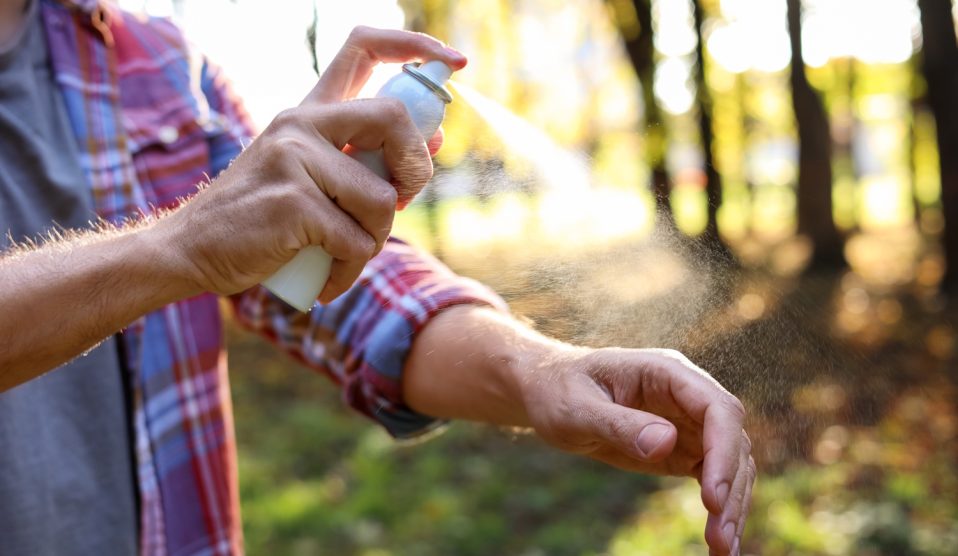 Egy férfi lefújja magát kullancsriasztóval