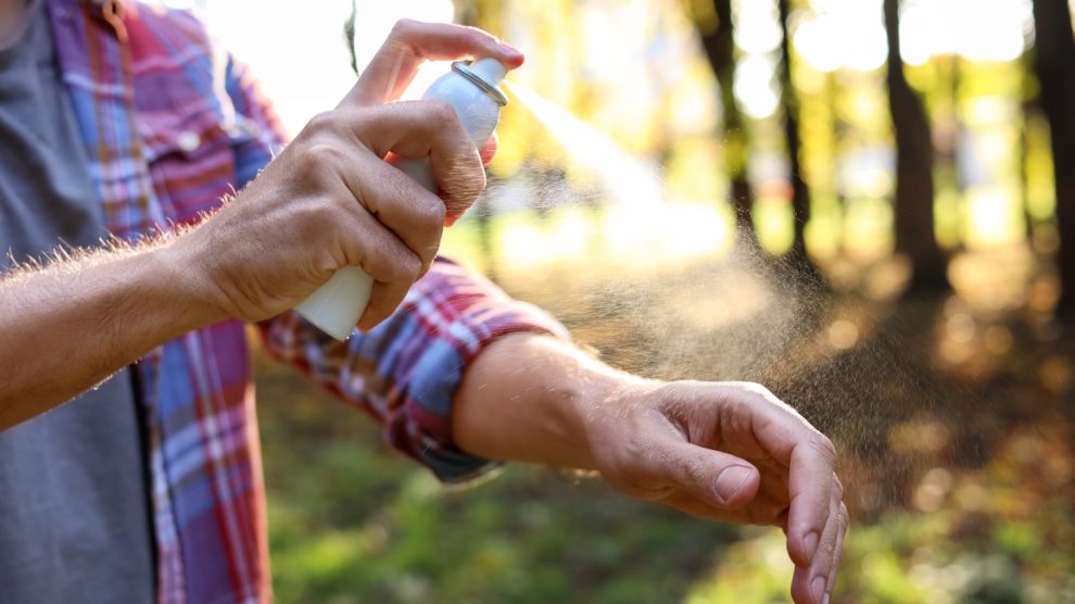 Egy férfi lefújja magát kullancsriasztóval