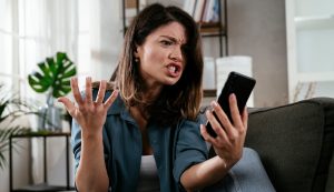 nő mérges a mobiltelefonjára, mert lassú