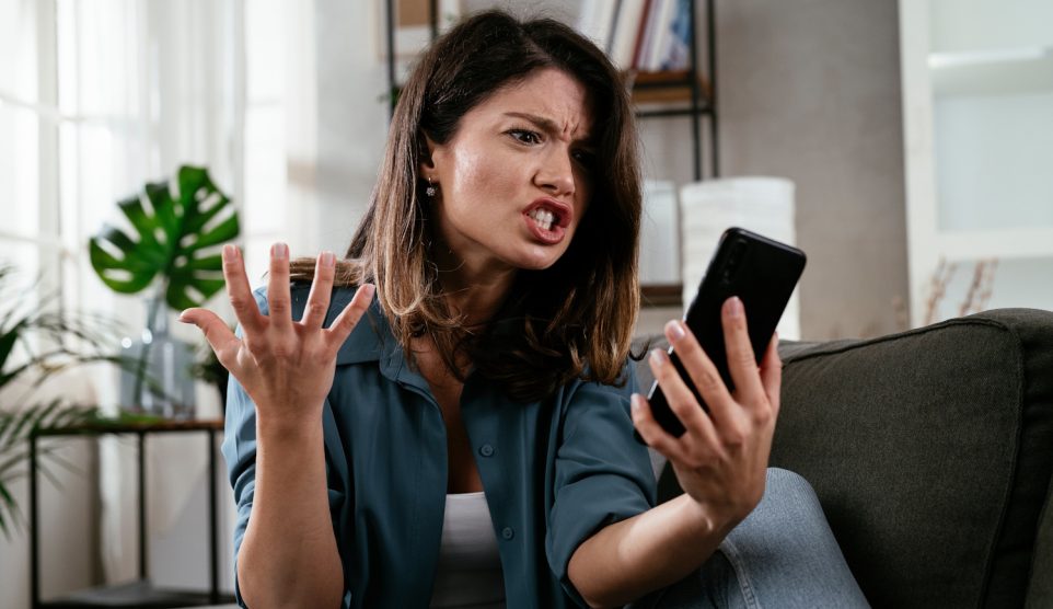 nő mérges a mobiltelefonjára, mert lassú