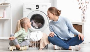 Anya és lánya ülnek a mosógép előtt