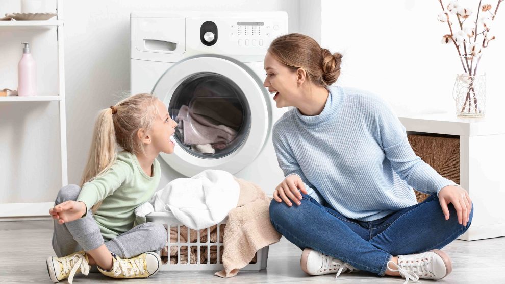 Anya és lánya ülnek a mosógép előtt