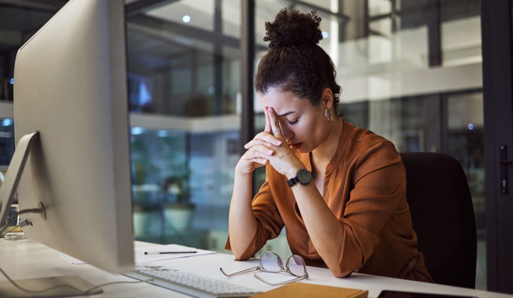 csüggedt fáradt nő este a munkahelyén fáradtan