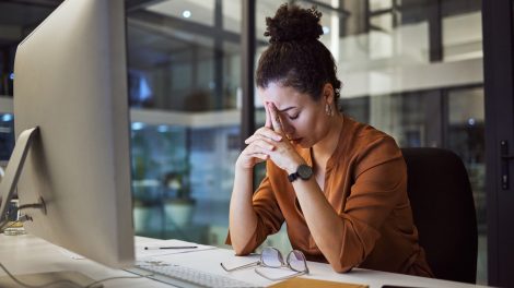 csüggedt fáradt nő este a munkahelyén fáradtan
