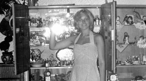 fiatal hölgy régi fekete-fehér fényképen a vitrinjét mutatja büszkén