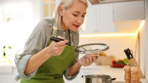 szép nagymama a konyhában főz kóstolja a levest