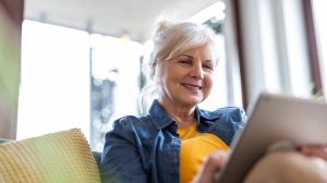 nyugdíjas nő örül a nappaliban