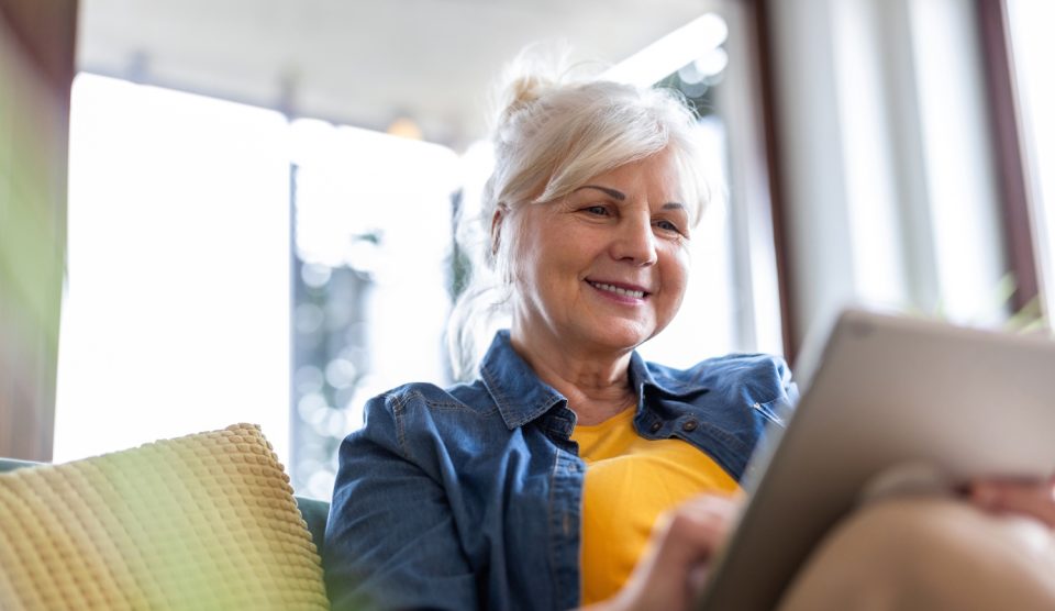 nyugdíjas nő örül a nappaliban